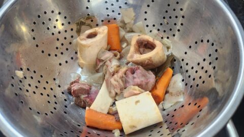 bone broth draining in colander