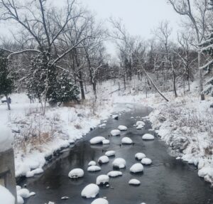 snow covered rocks on a river
