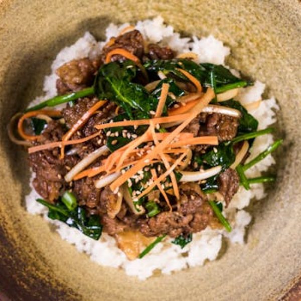 Deliciously vibrant Korean bibimbap topped with marinated bulgogi beef and fresh vegetables.